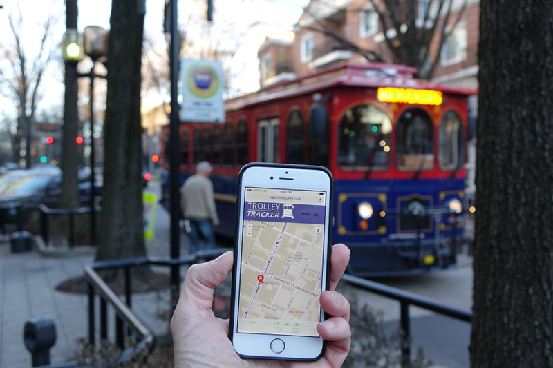 Photo of mobile phone with Trolley Tracker software. Downtown Greenville trolley in background.
